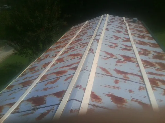 Rusted metal roof panels with new wood purlins before replacement — Storm Damage Roof Repair in Robertsville by Roofing Brothers