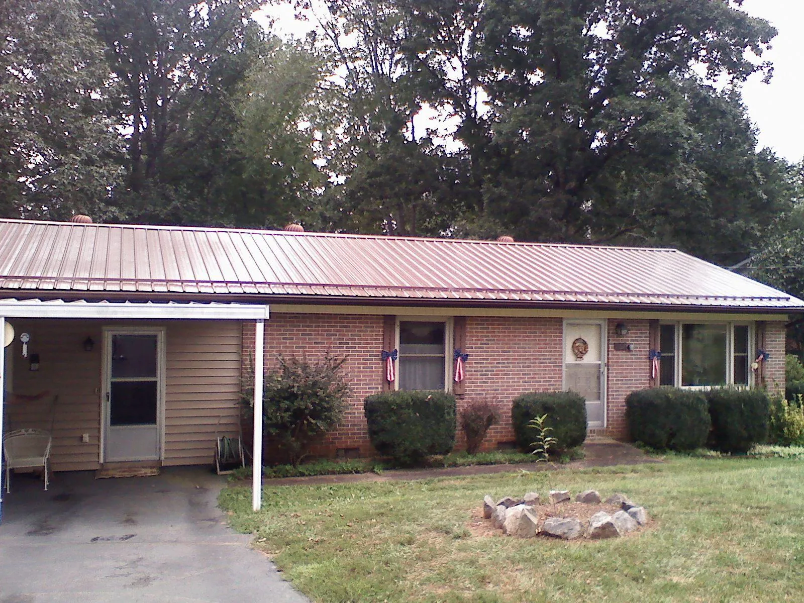 Bronze metal roof and carport on a brick ranch home — Roof Repair work by our crew in Robertsville